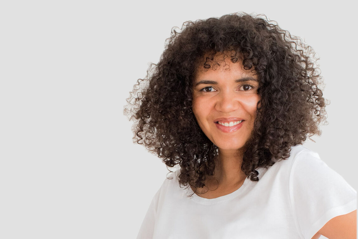 Tebogo Nimindé-Dundadengar trägt ein kurzes, weißes Shirt und lächelt in die Kamera.